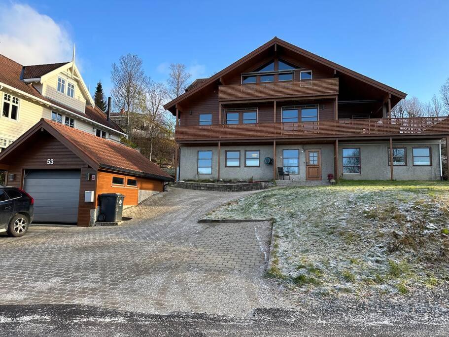 une grande maison avec une allée en face de celle-ci dans l'établissement Leilighet i rolig gate med utsikt og gratis parkering, à Tromsø