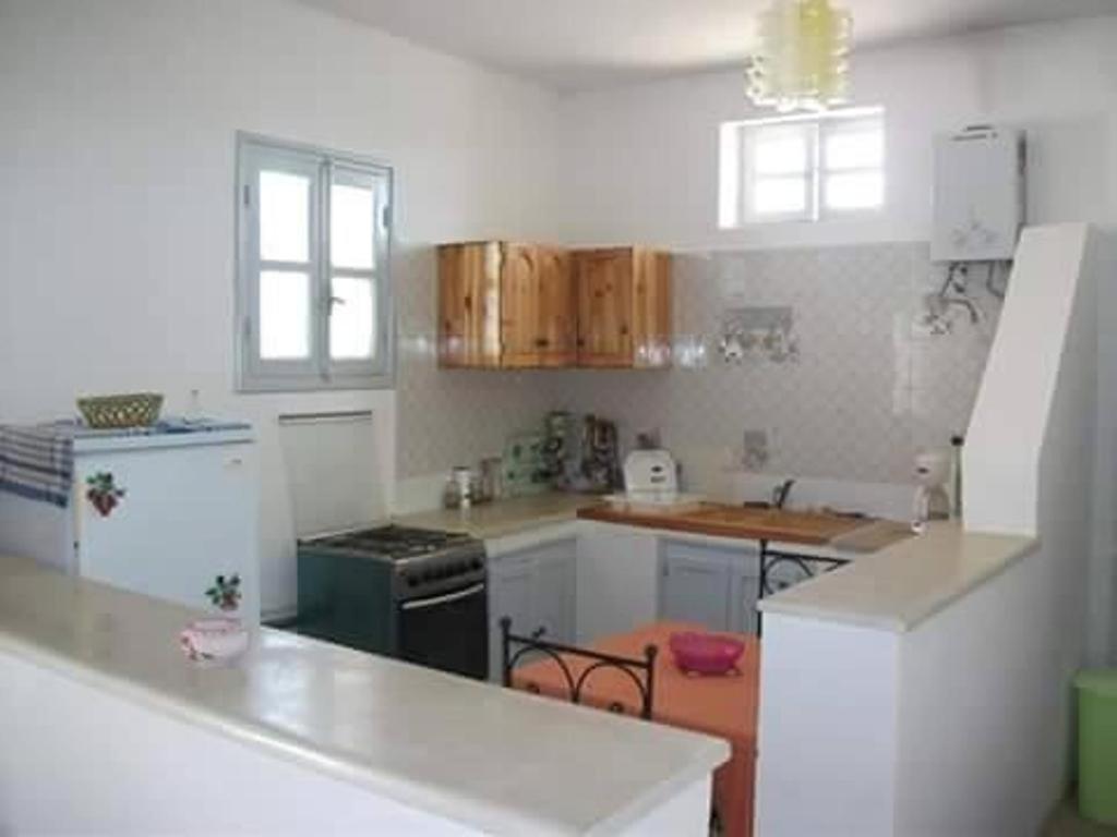 a kitchen with white cabinets and a white counter top at Diar Karim Djerba in Midoun