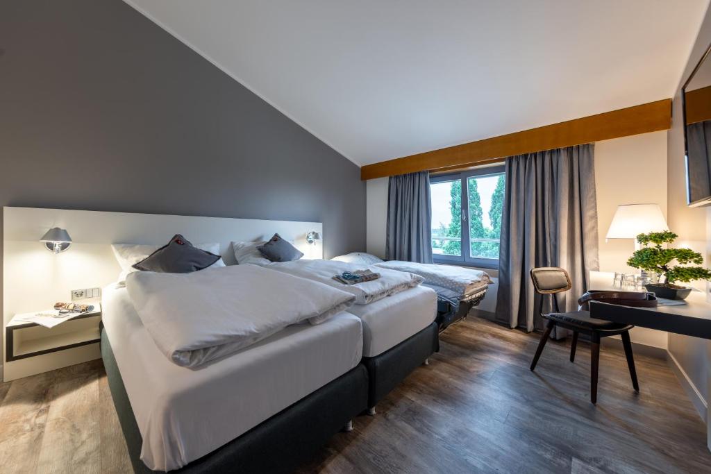 Postel nebo postele na pokoji v ubytování Hotel Leipheim Süd