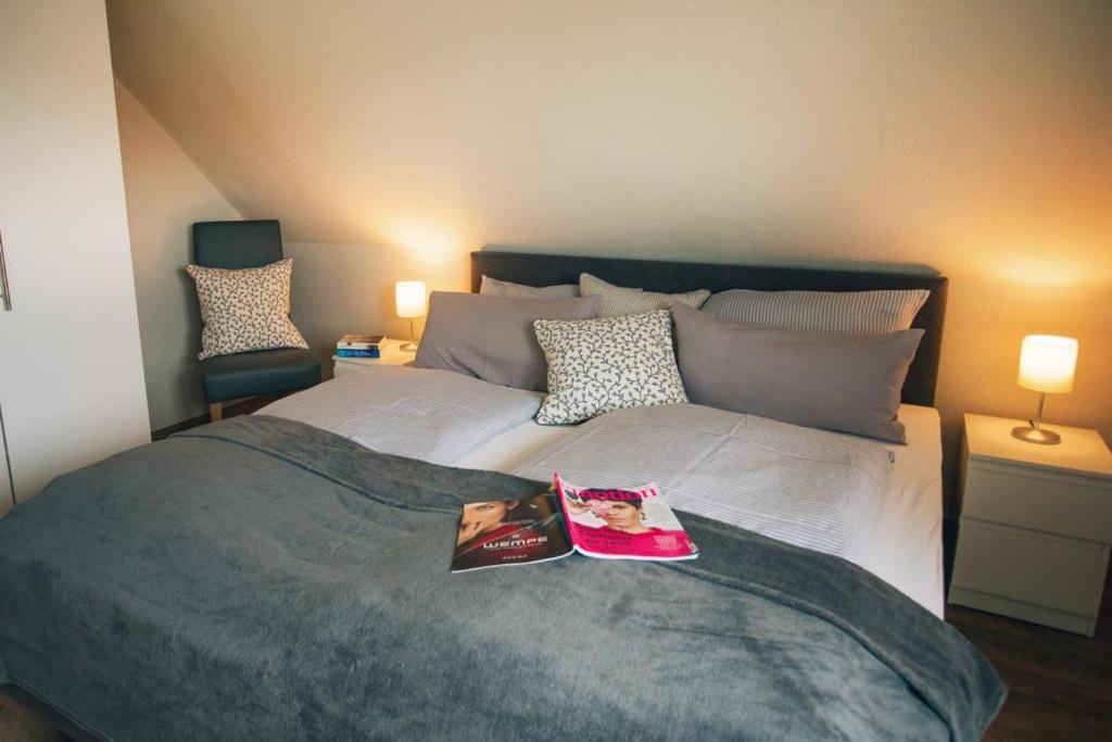 Un dormitorio con una cama con dos libros. en Haus Jelena Appartement 2 en Borkum