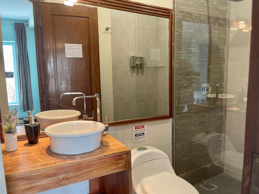 La salle de bains est pourvue de toilettes, d'un lavabo et d'une douche. dans l'établissement Hotel Mia Inn, à La Paz