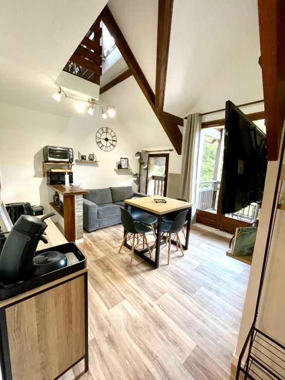 un salon avec une table et un canapé dans l'établissement Duplex du Pailhet, T3 neuf, vue montagne, parking, navette et 2 vélos à disposition gratuitement, à Luchon