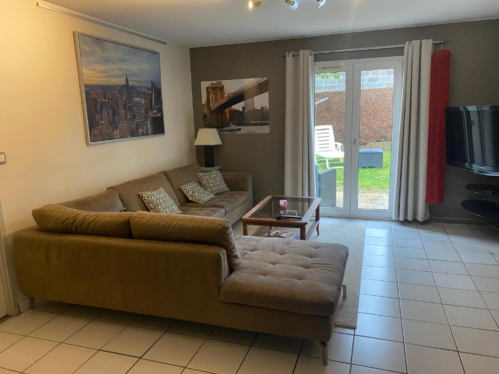 un salon avec un canapé et une table dans l'établissement Maison 3 chambres, salle de gym, jardin et terrasse, à Caen