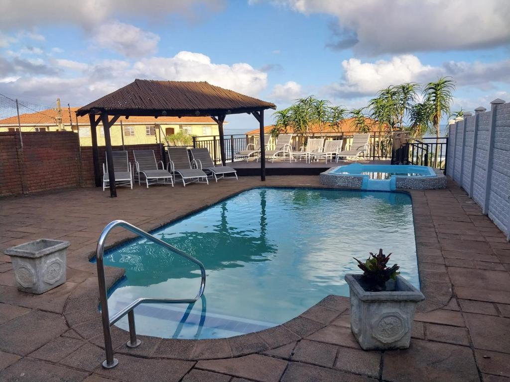 - une petite piscine avec un kiosque et des chaises dans l'établissement Illovo Views Holiday Apartment, à Kingsborough