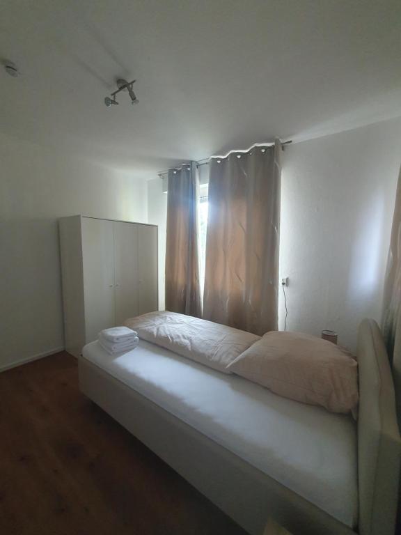 Schlafzimmer mit einem Bett und einem Fenster mit Vorhängen in der Unterkunft Privatzimmer im Schlesischen Viertel - nahe Uniklinik in Mainz