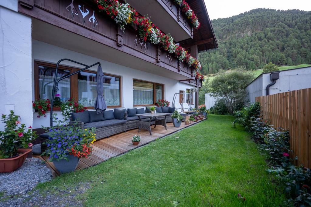 a backyard with a couch on a wooden deck at Gästehaus -Pension Edelweiss in Vent
