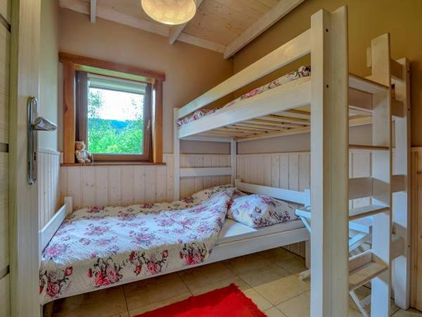 a bedroom with two bunk beds and a window at Domki BIOSEN in Podgórzyn