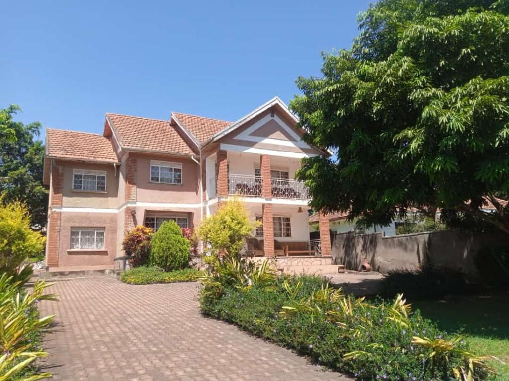 een groot huis met een stenen oprit bij Lakeview Serenity in Entebbe