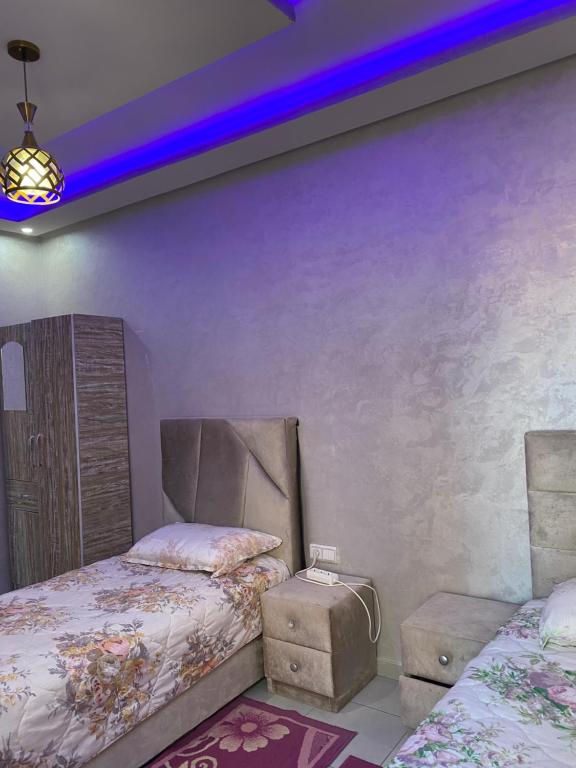 1 dormitorio con 2 camas y techo púrpura en holiday and beach self check-in en Agadir