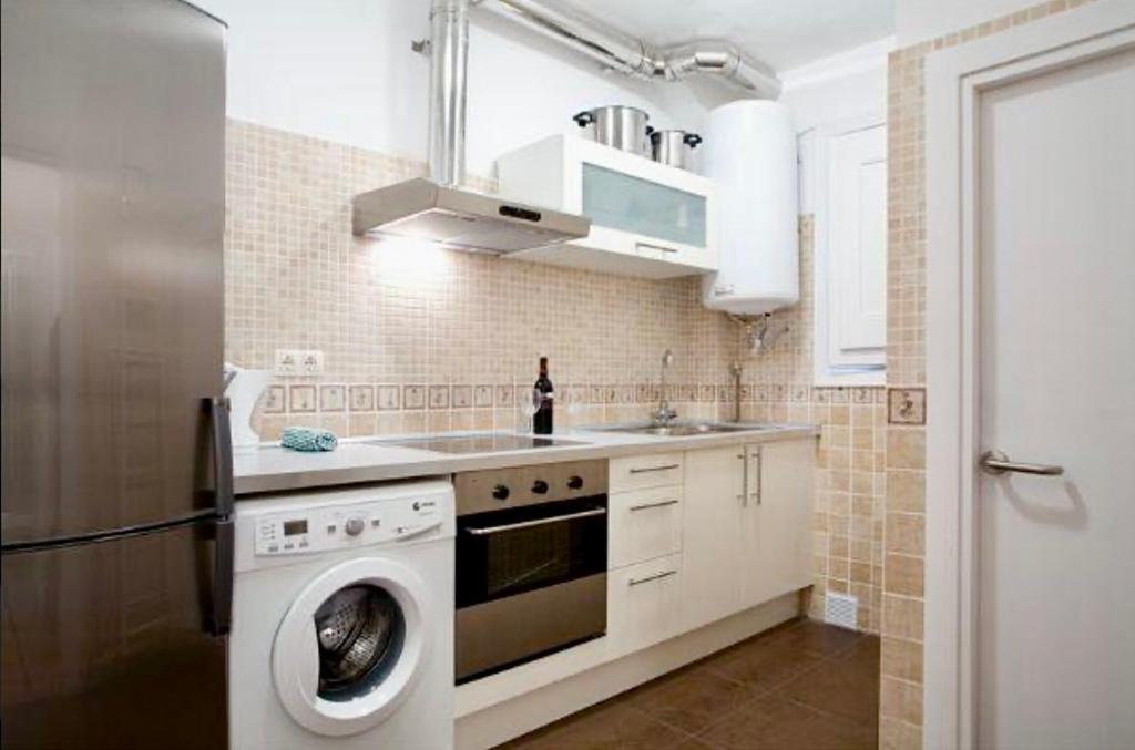 cocina con lavadora y fregadero en 5-bed apartment in the heart of the city en Barcelona