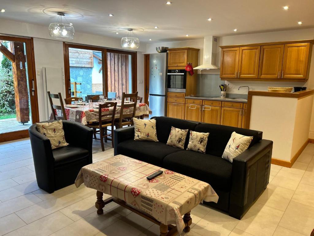 un salon avec un canapé et une cuisine avec une table dans l'établissement Appartement Spacieux - Terrasse, Jardin et Cheminée - À 5 Min du Centre des Gets - FR-1-623-100, aux Gets