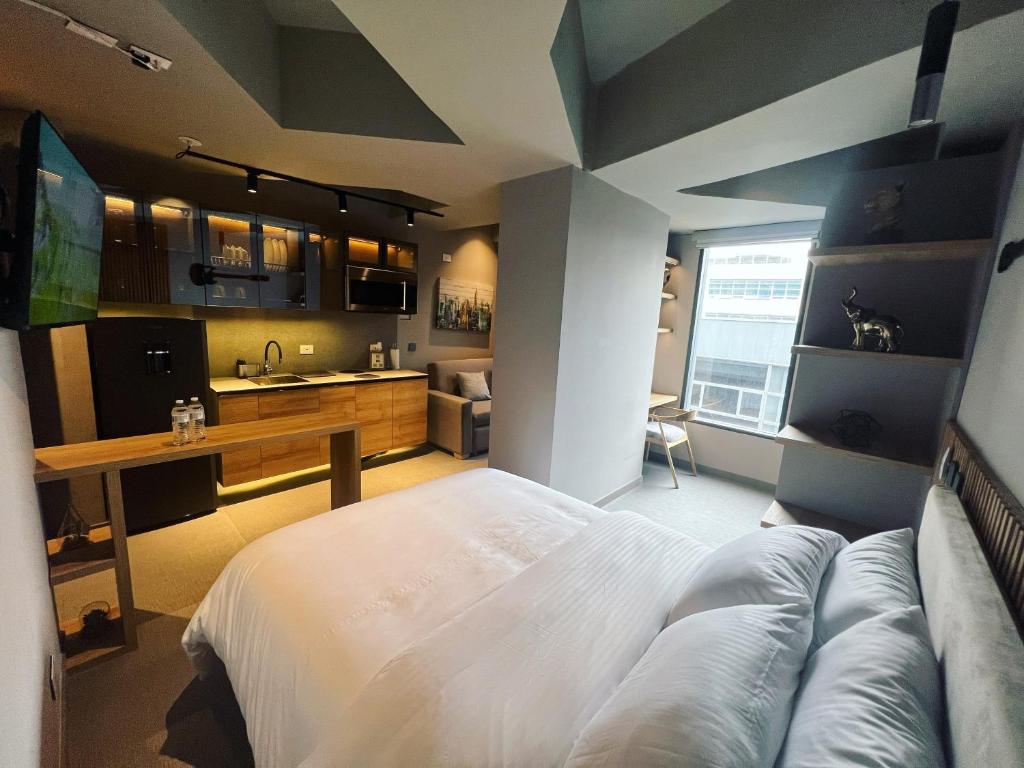 a bedroom with a large bed and a kitchen at Unique Mine Luxury SMART LOFTS in Bogotá