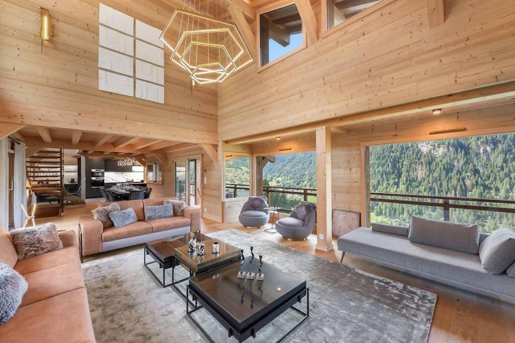 シャテルにあるBlack Diamond - Chalet - BO Immobilier- remises sur les forfaits de skis Châtel ou Portes du soleilのリビングルーム(家具付)、大きな窓が備わります。