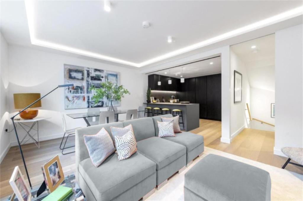 a living room with a couch and a kitchen at Exclusive Premium St James Apartment in London