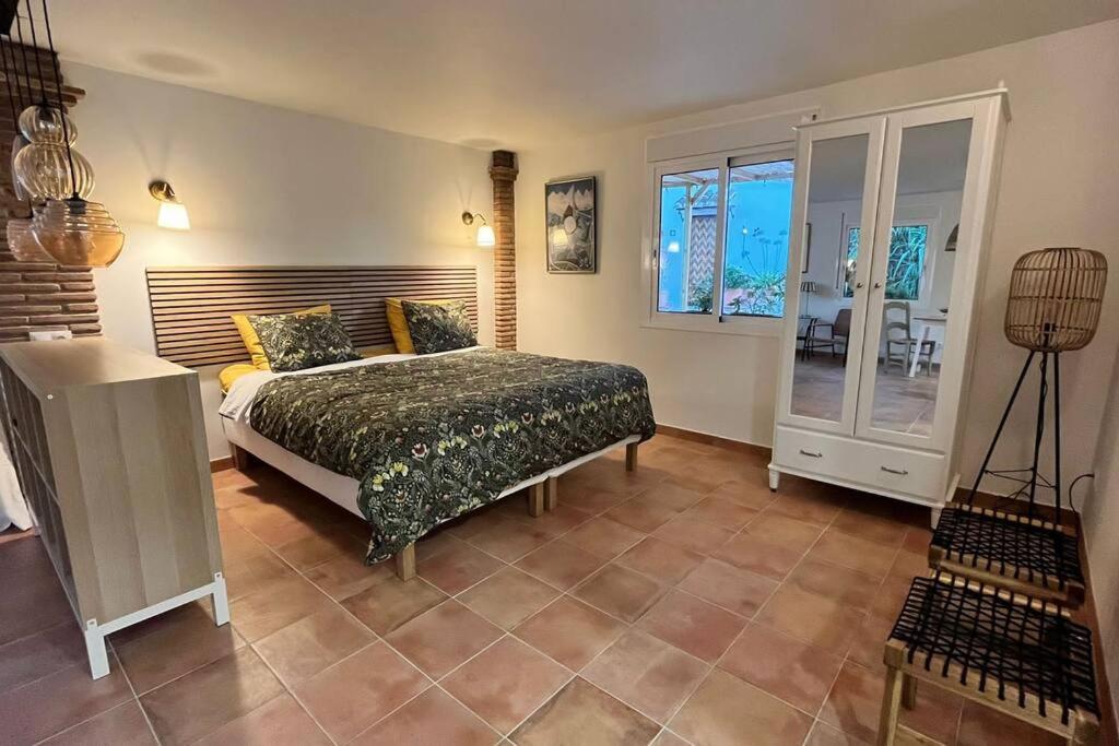 een slaapkamer met een bed en een groot raam bij La Sureña in Alhaurín el Grande