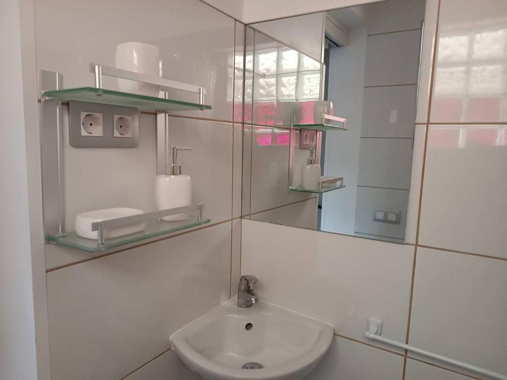 uma casa de banho branca com um lavatório e um espelho em Casa Celia em Valsequillo
