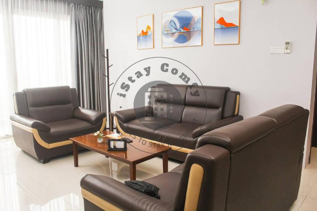 una sala de estar con 2 sofás de cuero y una mesa. en 3BR Aston Residence 2001 City and Sea View, en Nagoya