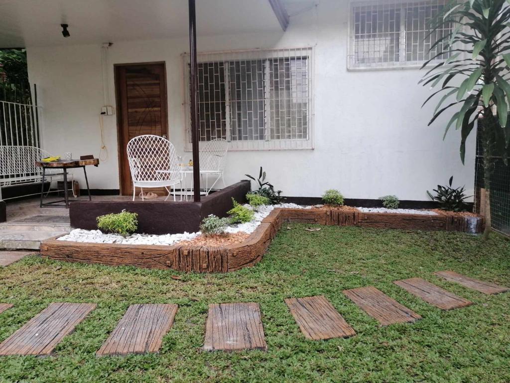 a garden with wooden steps in front of a house at FAST Wifi 400 Mbps Tiny House in Bacolod City in Bacolod