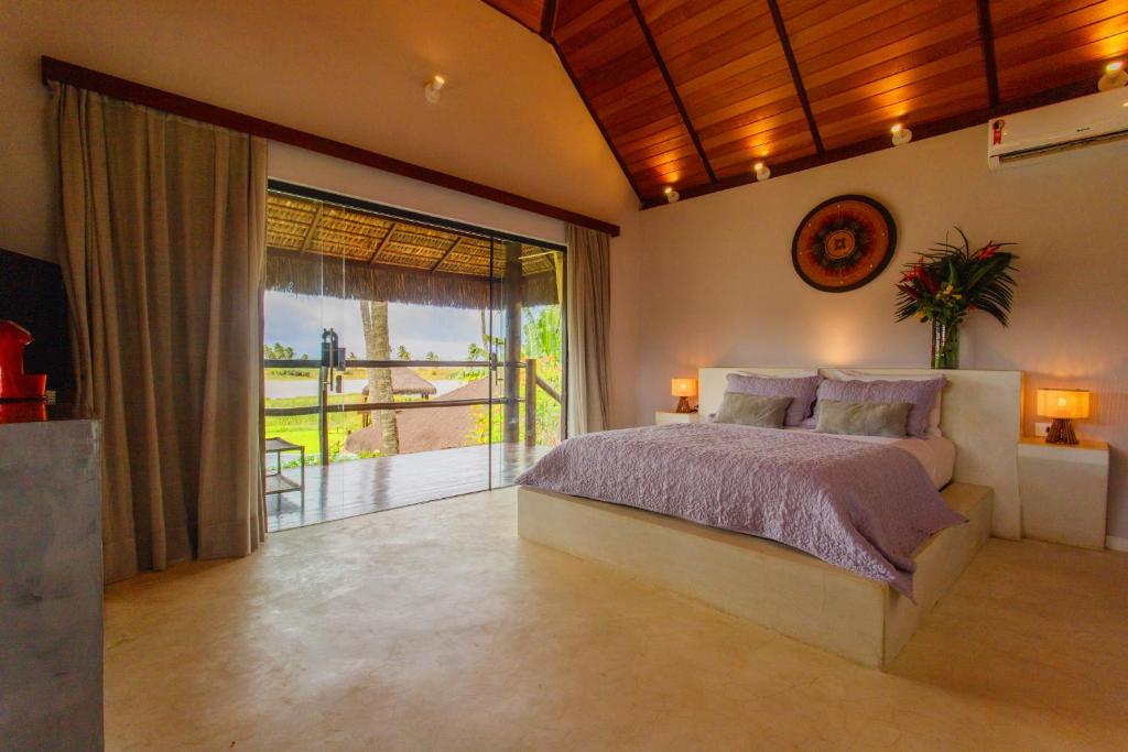 a bedroom with a large bed and a balcony at Jaya Pousada Boutique in São Miguel do Gostoso