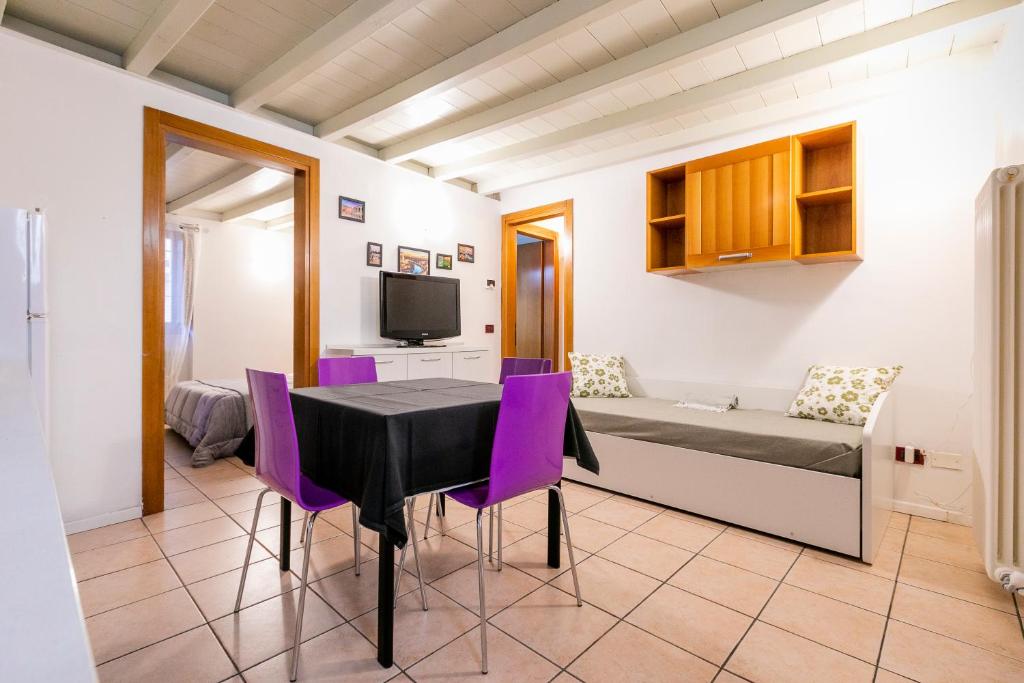 a dining room with a table and purple chairs at Sweet House a Veronetta - A pochi metri dal Centro in Verona