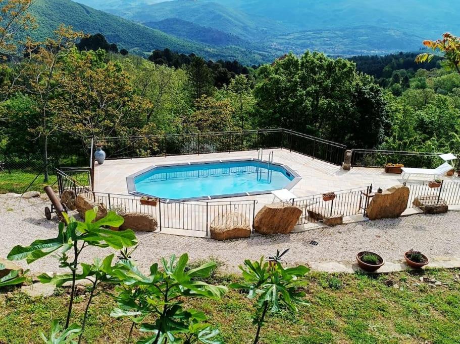 een groot zwembad met stoelen eromheen bij Rustico Toscano in Castel Focognano
