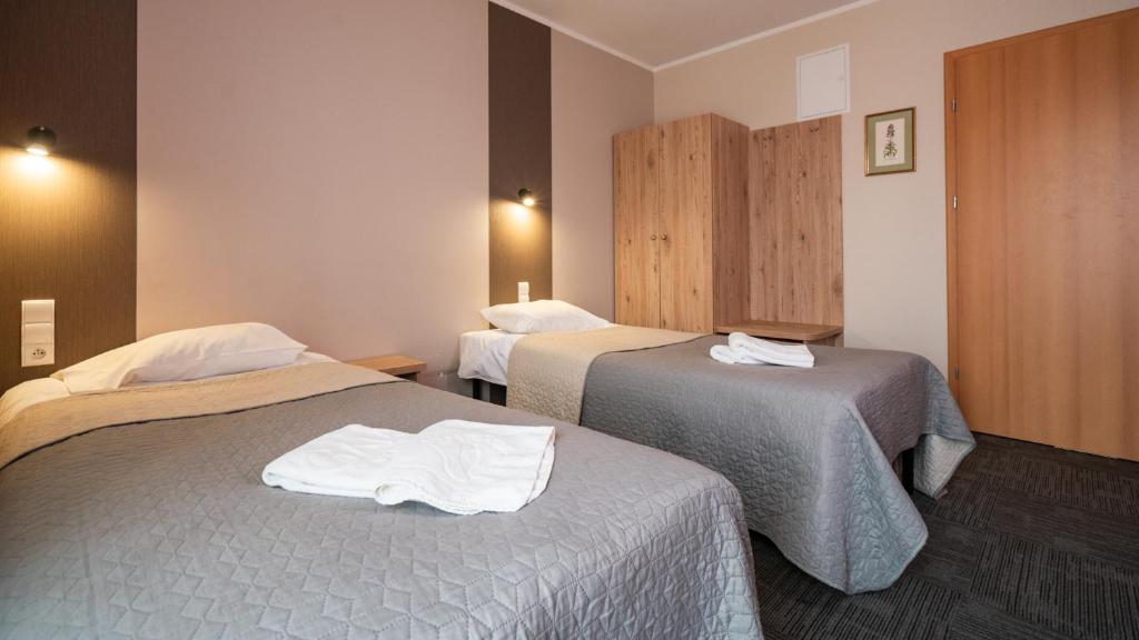 Hotel Gaja في وارسو: غرفه فندقيه سريرين عليها مناشف