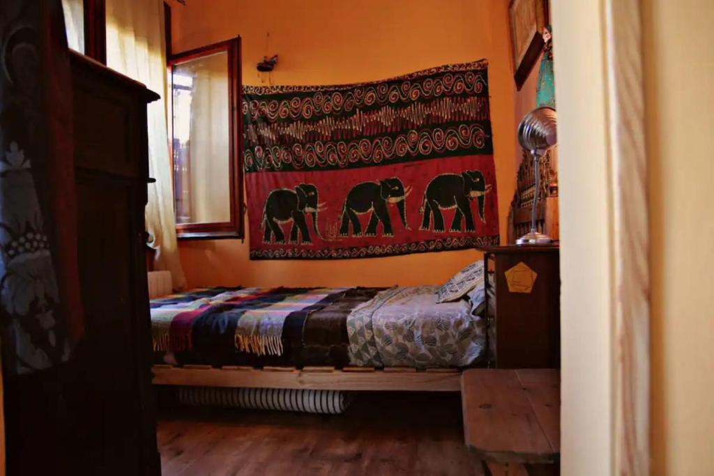 a bedroom with a bed and a rug on the wall at Casita de Bosque in Arbúcies