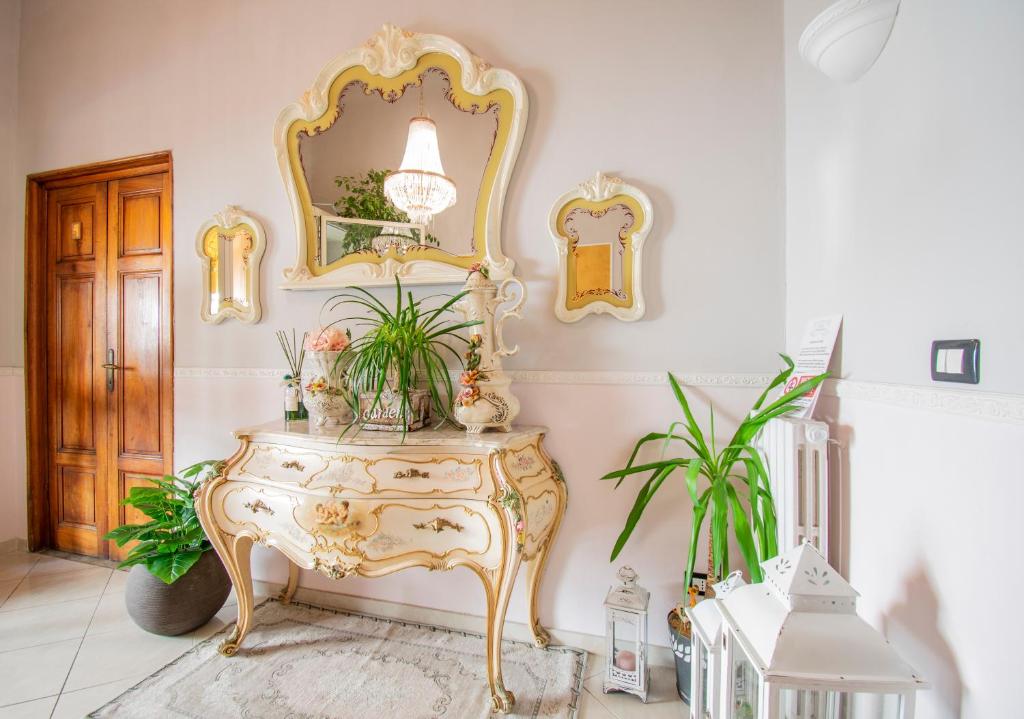 a room with a table with a mirror and plants at Hotel Albachiara in Viareggio