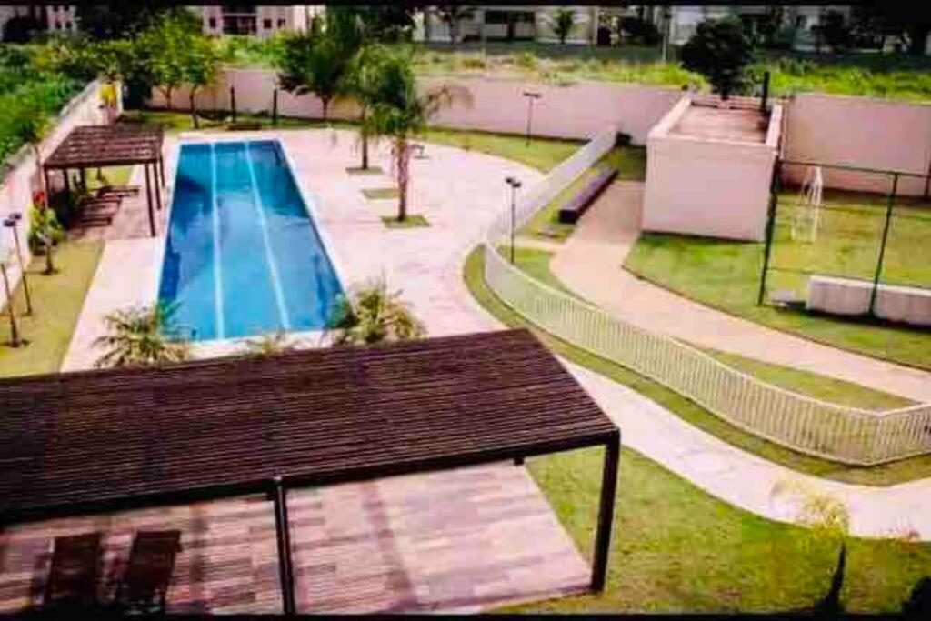 una vista aérea de una piscina con un banco de madera en Apartamento 133 Magnífico!, en Ribeirão Preto