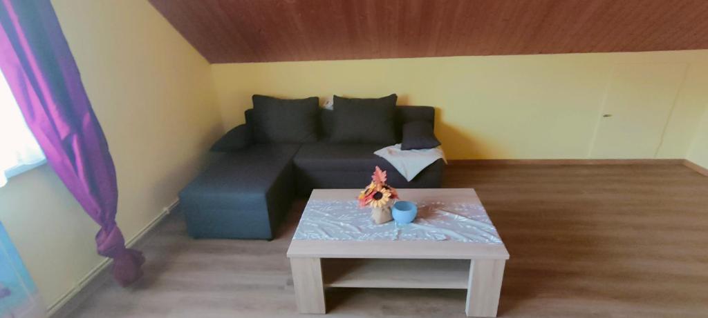 ein Wohnzimmer mit einem Sofa und einem Tisch in der Unterkunft Ferienwohnung Burmester in Wittenborn