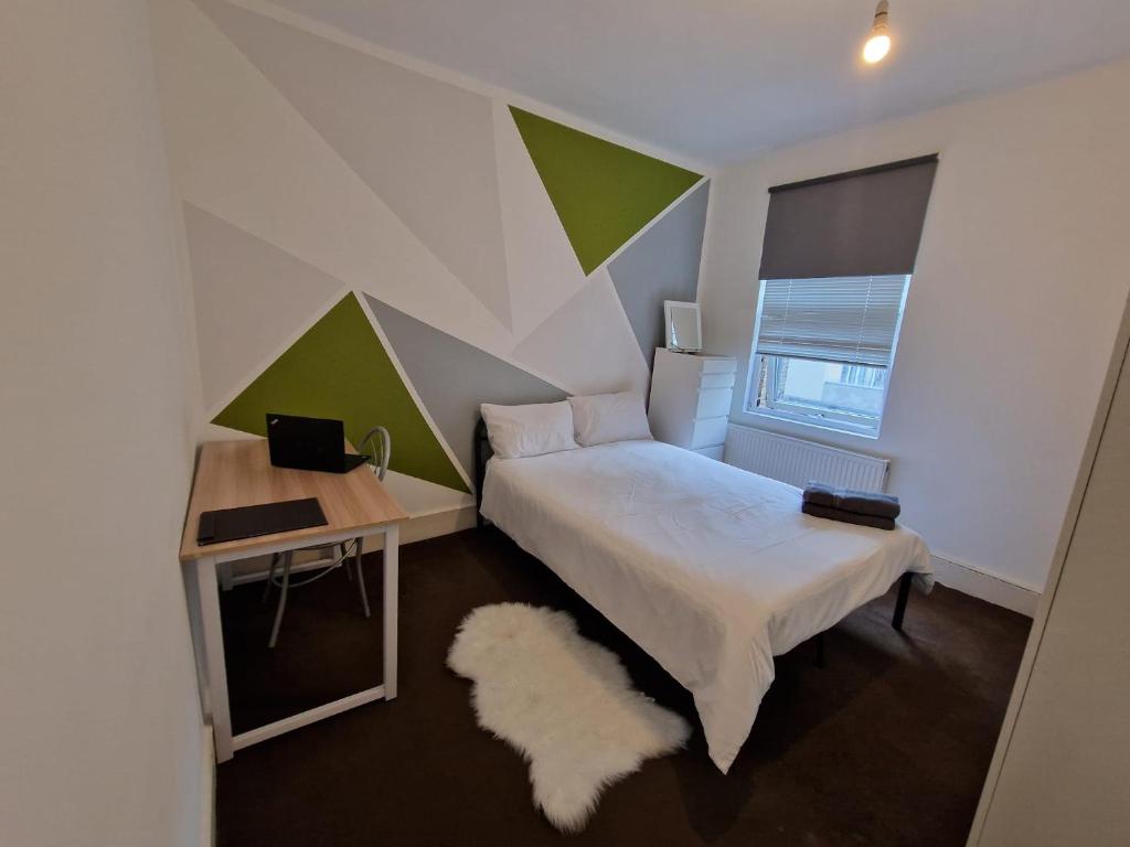 una camera con letto e scrivania con computer portatile di Brewery rd Double room a Plumstead