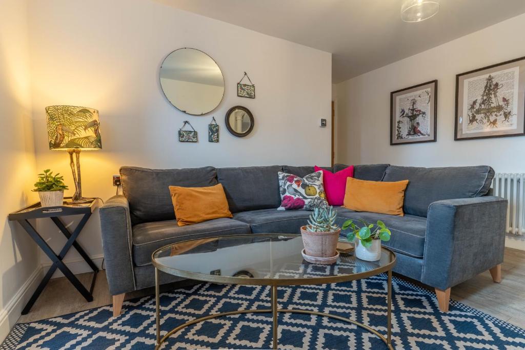 uma sala de estar com um sofá azul e uma mesa de vidro em Luxury Chapel Apartment within City Walls em Chester