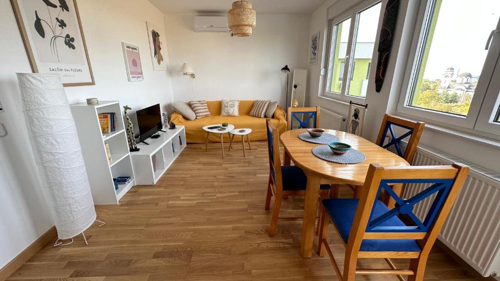 - un salon avec une table et un canapé dans l'établissement Tranquil apartment across the bridge, à Novi Sad