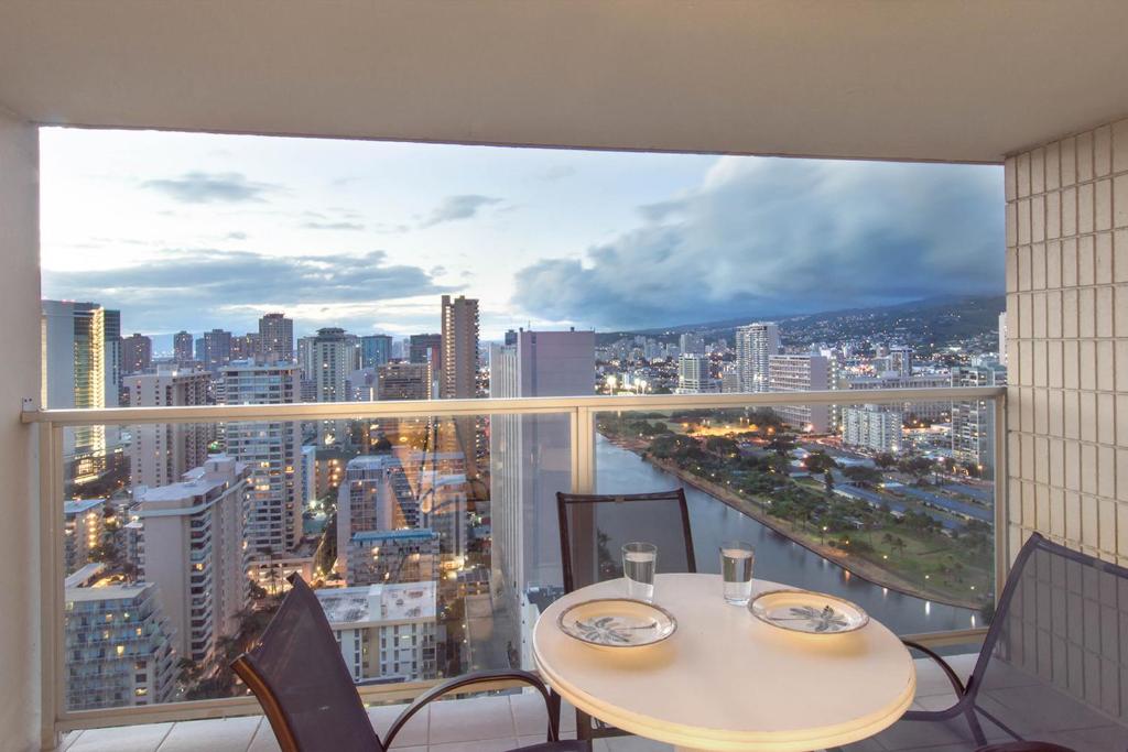 a table and chairs in a room with a view of a city at Island Colony 3512 in Honolulu