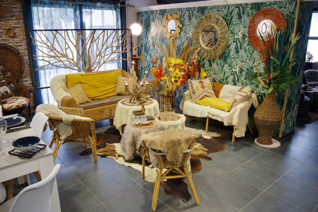 un salon avec des canapés, des chaises et une table dans l'établissement Cottage des Deux Époques - CareHost, à Saint-Genis-de-Saintonge