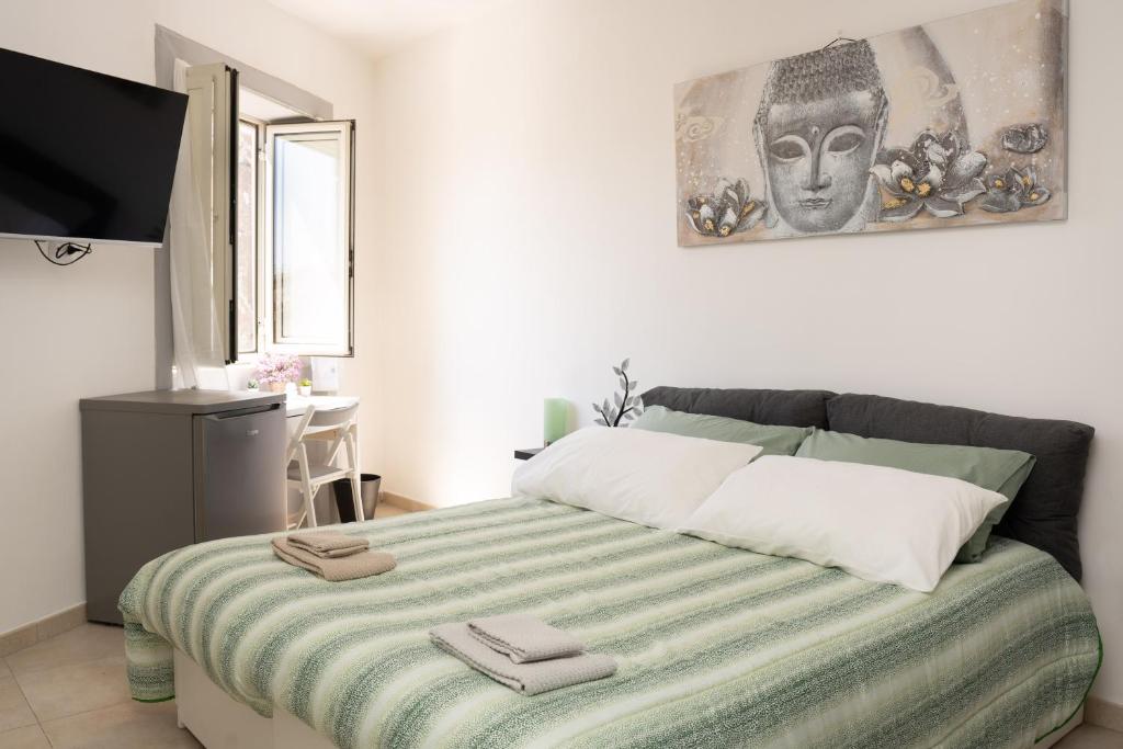 1 dormitorio con 1 cama con manta verde y blanca en La Julienne Green, en Nápoles