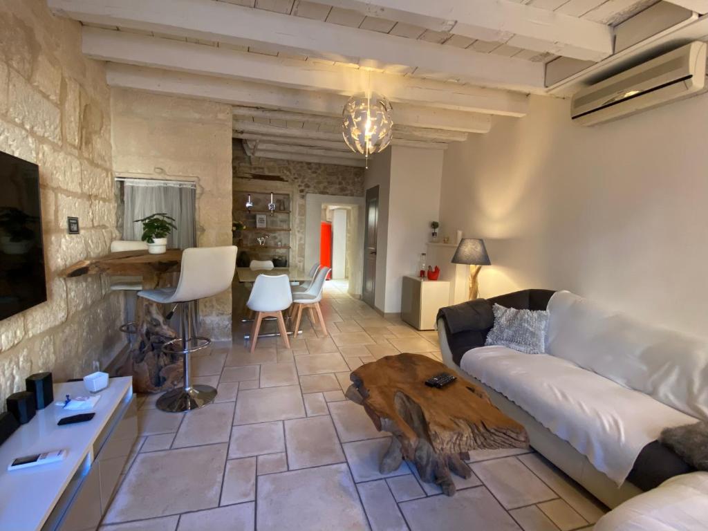 un salon avec un canapé et une table dans l'établissement Bienvenue au 6 - Calme et charme de la pierre., à Fourques