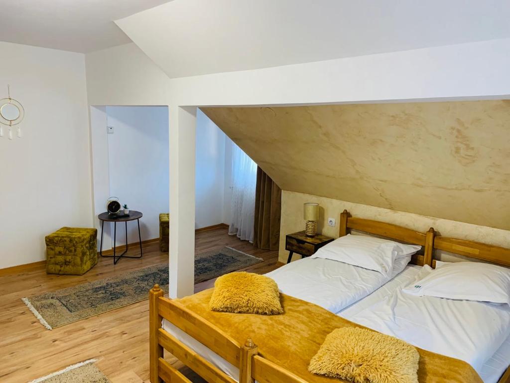 um quarto com uma cama de madeira e lençóis brancos em Casa din Vale em Moieciu de Sus