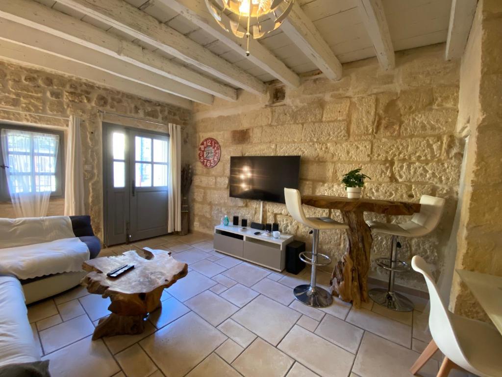 a living room with a couch and a table at Bienvenue au 6 - Calme et charme de la pierre. in Fourques