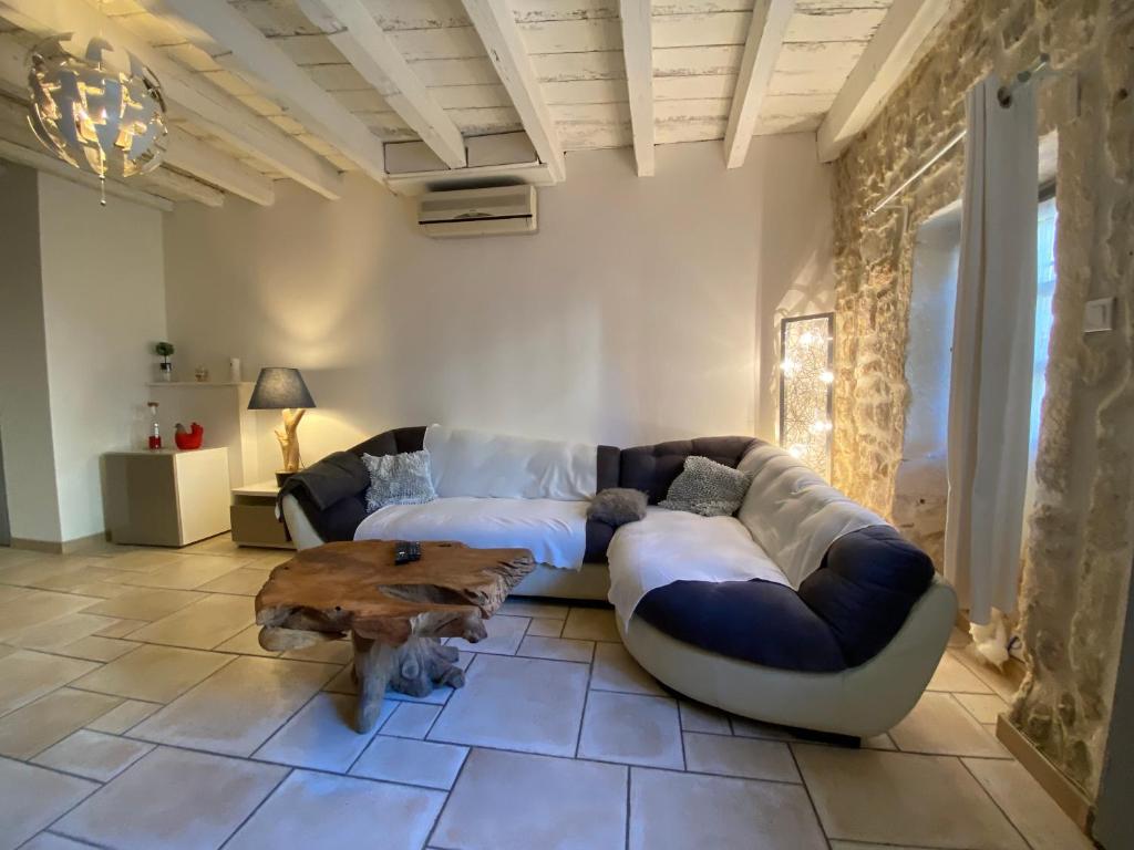 a living room with a couch and a coffee table at Bienvenue au 6 - Calme et charme de la pierre. in Fourques