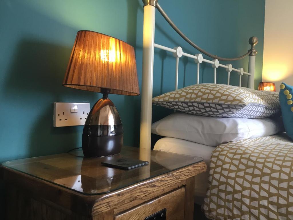 a bedroom with a bed and a lamp on a table at Seaham in Weymouth