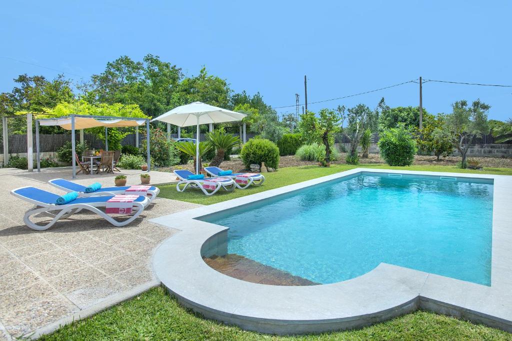 una piscina con sillas y sombrillas en un patio en Owl Booking Villa Margarita - 15 Min Walk to the Beach, en Puerto Pollensa