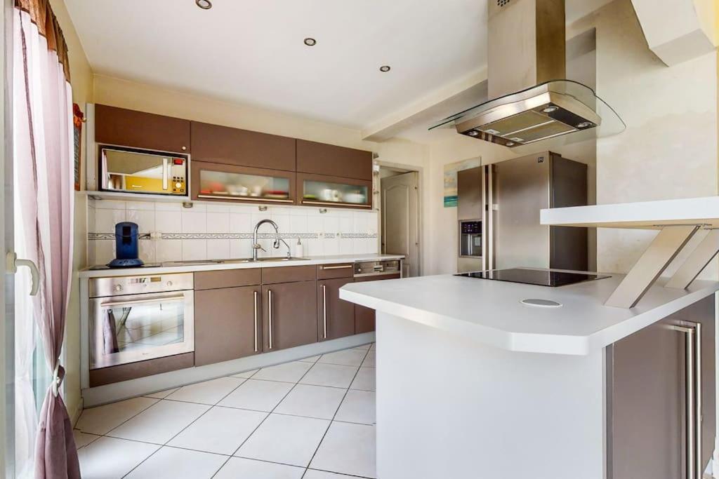 a kitchen with a white counter top and a sink at Maison quartier résidentiel in Saint-Priest