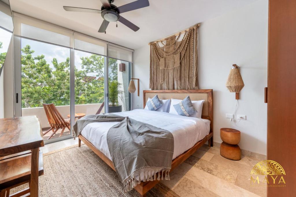 图卢姆NHOA 311B Lux 1BR Condo Pool View in Aldea Zama的一间卧室，里面有一张床和一扇大窗户。