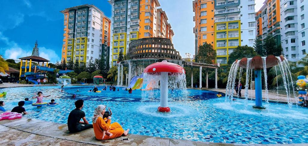 eine Gruppe von Menschen, die in einem Pool mit einem Brunnen sitzen in der Unterkunft Wet Spot Amusement Water Themepark Family Suite - Enjoy Biggest Water Themepark Fun in Melaka Town in Malakka