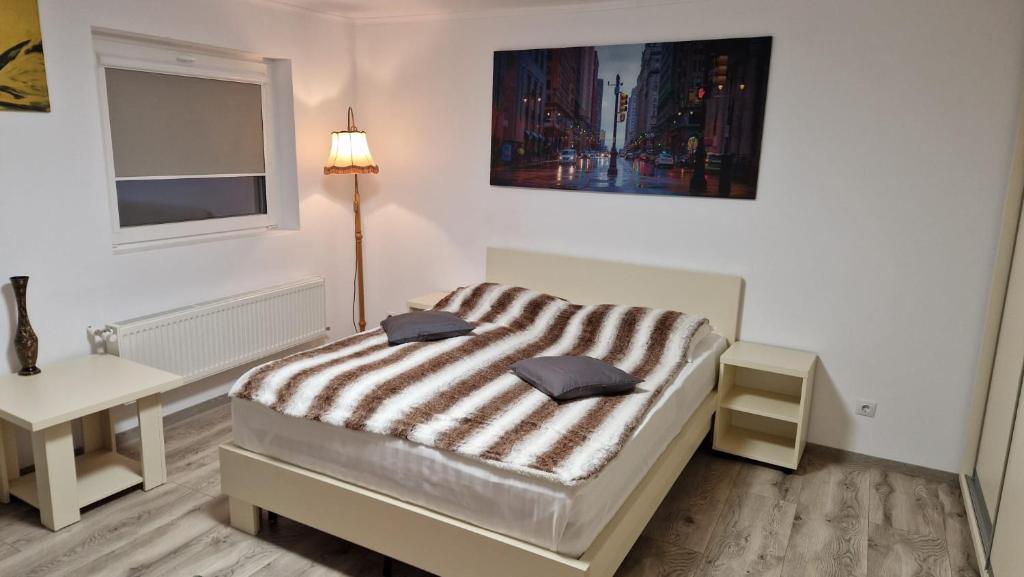 1 dormitorio con 1 cama con manta a rayas en Casa Teo, en Buzau