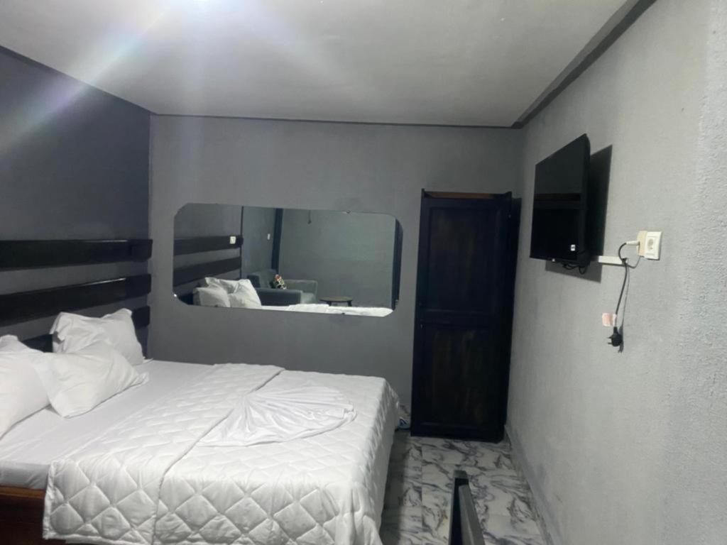 um quarto com uma cama e um espelho grande em Sunrise Center Bonapriso - 107 em Douala