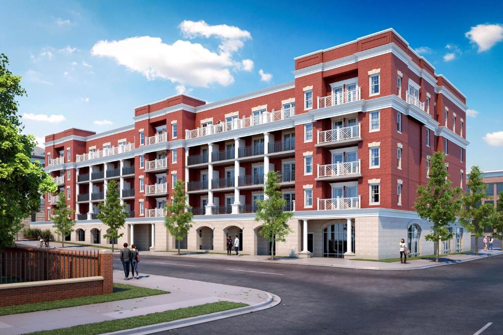 an architectural rendering of a red building on a street at The Publisher, Fredericksburg, a Tribute Portfolio Hotel in Fredericksburg