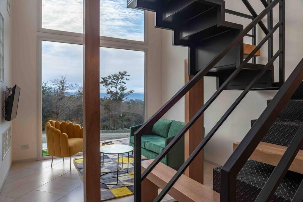 a living room with a spiral staircase and a large window at Miradores del Susana Duplex III in Ushuaia