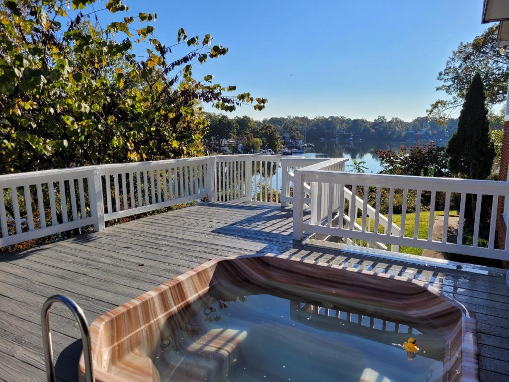 a plunge pool on a wooden deck with a view of the water at Serene 5 Bedroom Waterfront Retreat Near BWI in Glen Burnie